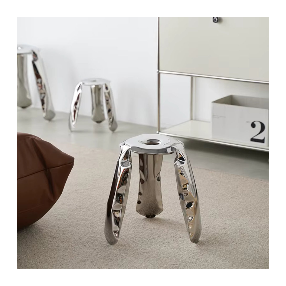 Moderner Polsterhocker in Silber mit Edelstahl-Design und dreibeiniger Metallkonstruktion - Bild 2